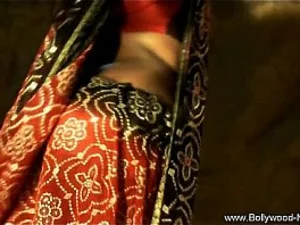 एक आकर्षक भारतीय नर्तकी प्रदर्शन करता है एक कामुक साया नृत्य, अंधेरे में तना हुआ है ।